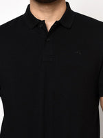 Model wears the 98degreenorth Men's Black Polo T-Shirt in stretch cotton pique, shown from shoulders to above the waist.