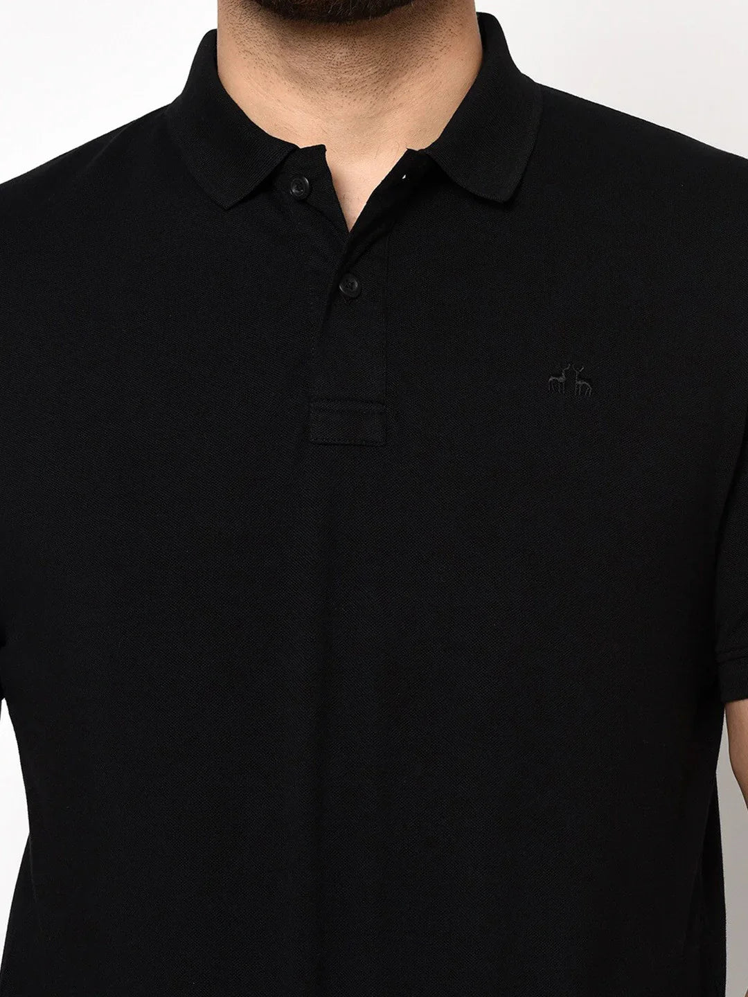Model wears the 98degreenorth Men's Black Polo T-Shirt in stretch cotton pique, shown from shoulders to above the waist.
