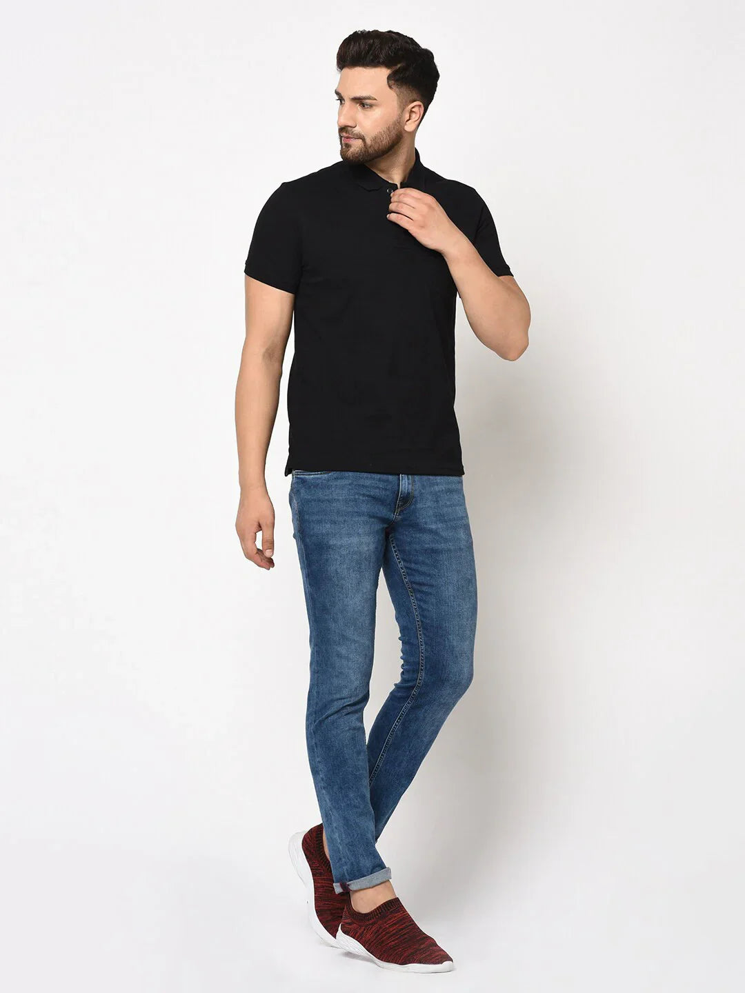 Man wears 98degreenorth Men's Black Polo T-Shirt, stretch cotton pique with chest pocket, blue jeans, red shoes.