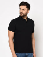 Man wears 98degreenorth Black Stretch Cotton Pique Polo with chest pocket and blue jeans; stands against plain background.