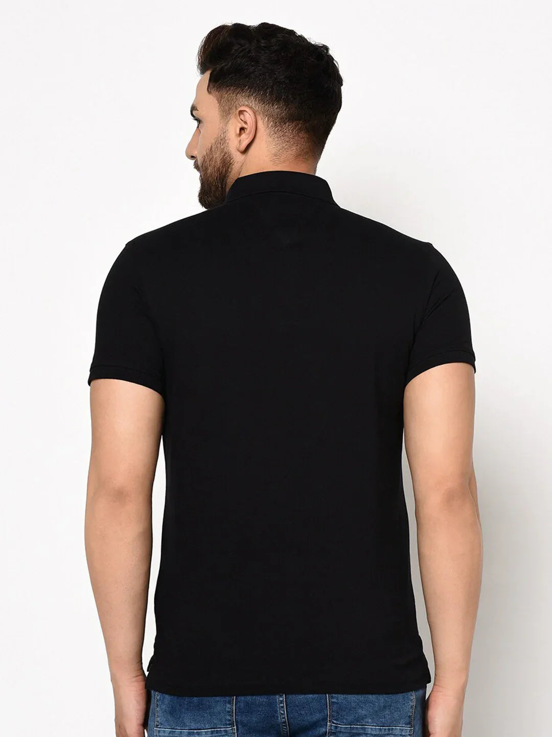 Man wearing 98degreenorth Men's Black Polo T-Shirt in stretch cotton pique with chest pocket, facing away.