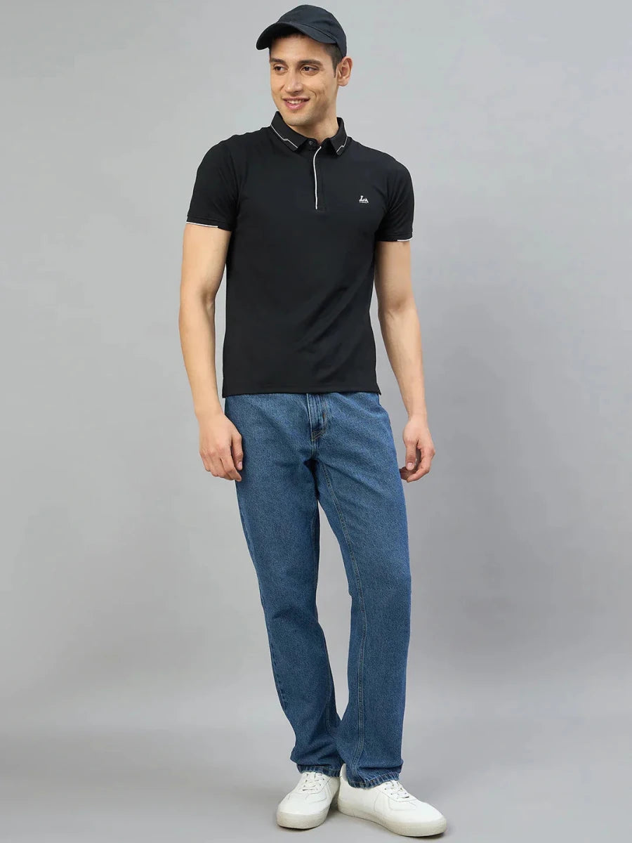 Man wears a 98degreenorth Men's Black Polo T-Shirt with White Tipping, blue jeans, white sneakers, and a black cap.
