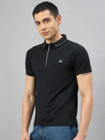 A man wears the 98degreenorth Men's Black Polo T-Shirt with White Tipping, standing against a light gray background.