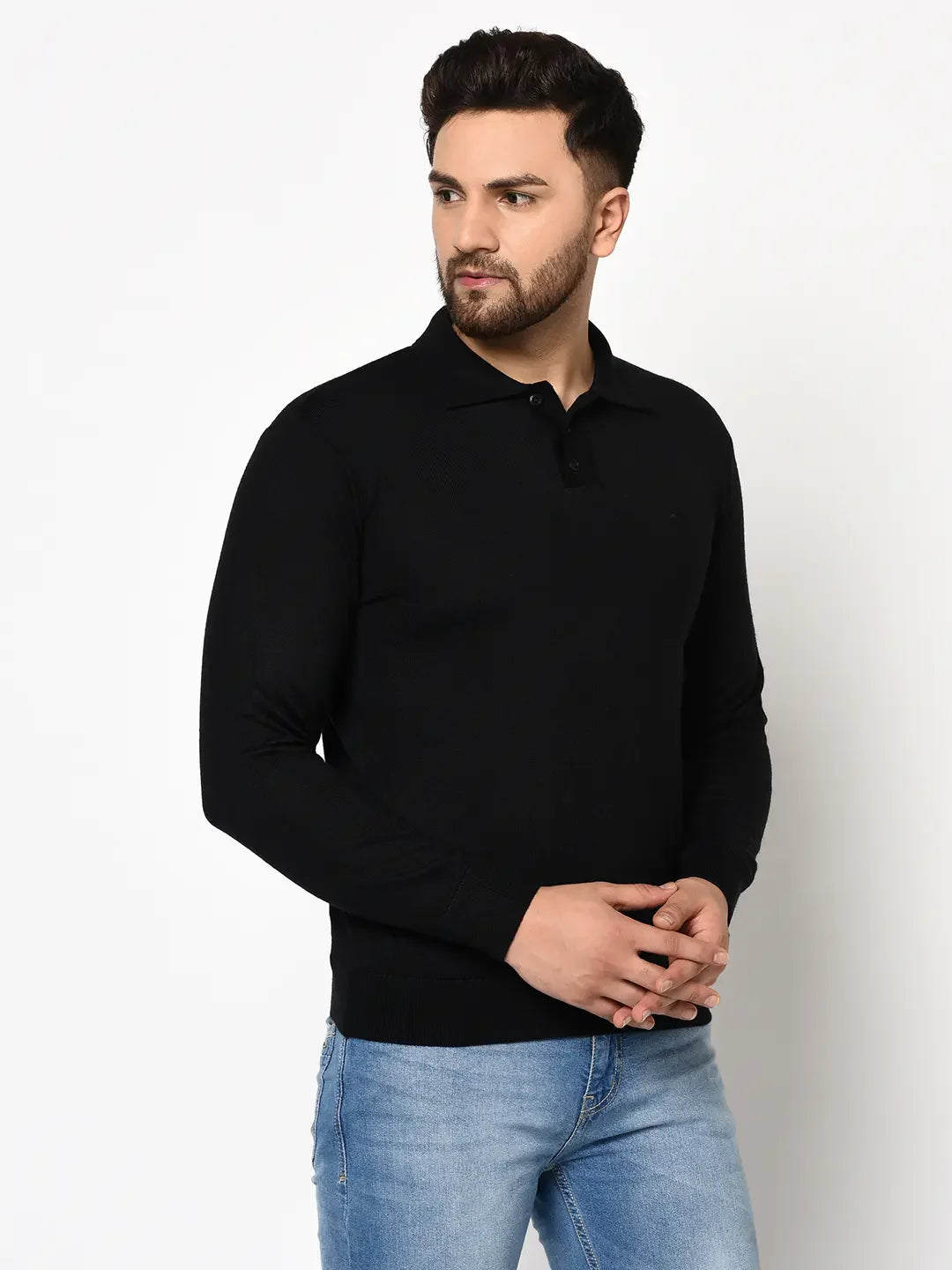Man wears a 98degreenorth Men's Black Premium Merino Wool Polo Neck Sweater with light blue jeans against a white background.
