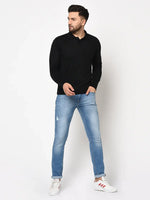 A man wears the 98degreenorth Men’s Black Premium Merino Wool Polo Neck Sweater—ideal winterwear for work or travel.