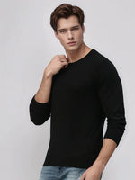 A man wears the 98degreenorth Men’s Black Premium Merino Wool Sweater, a luxury handcrafted knit pullover.