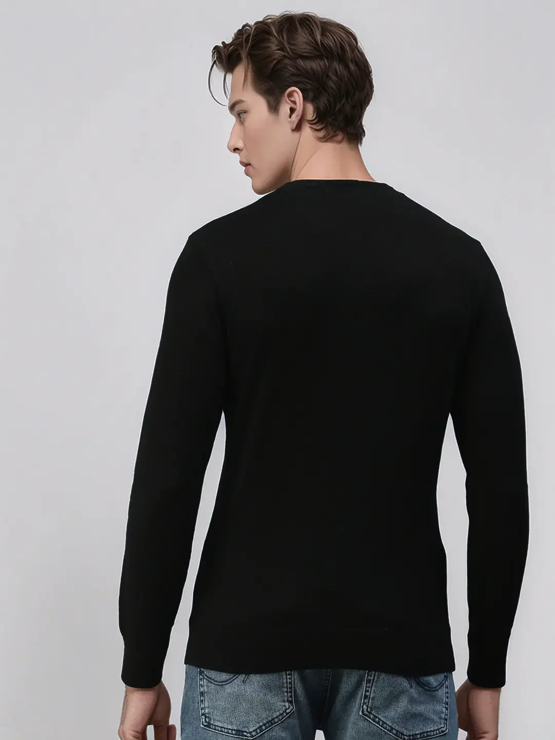 Man in 98degreenorth Men’s Black Merino Wool Sweater, handcrafted luxury knit, standing with back to camera.
