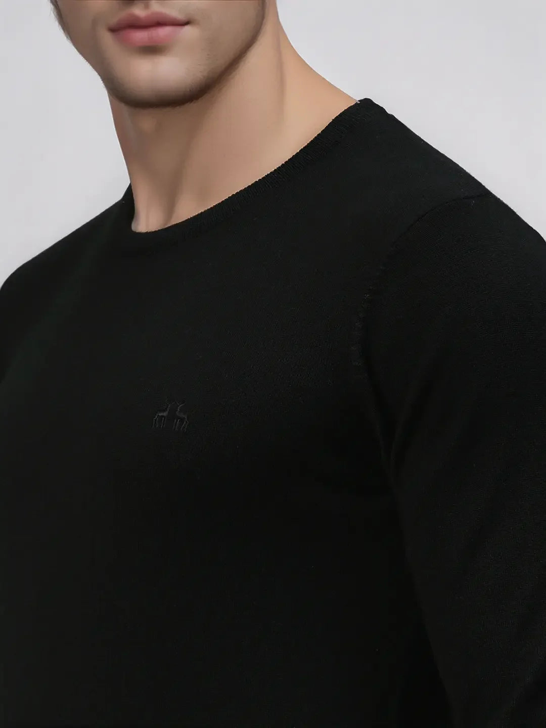 Man in 98degreenorth Men’s Black Premium Merino Wool Sweater, shown shoulder to mid-chest against light background.