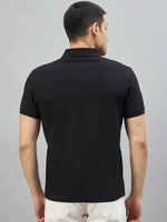 A man models the 98degreenorth Men's Black Quarter Zip Polo T-Shirt—Popcorn Knit against a gray background.