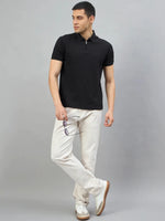 Man in 98degreenorth Men's Black Quarter Zip Polo T-Shirt, standing against a plain gray background.