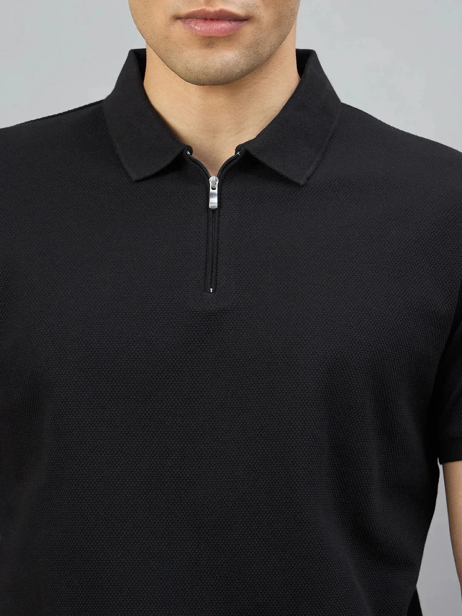 Man wears 98degreenorth Men's Black Quarter Zip Polo T-Shirt—Popcorn Knit, shown from shoulders to mouth.