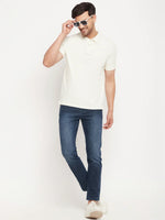 Man in a 98degreenorth butter yellow striped polo, blue jeans, white sneakers & sunglasses against a white background.