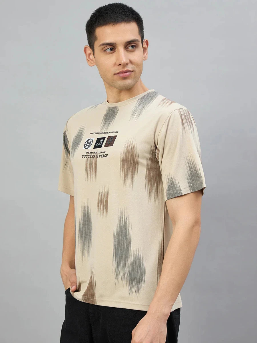 Man wearing a Men's Camel Abstract Ikat Print T-Shirt by 98degreenorth, standing against a plain gray background.