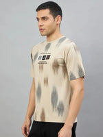 Man in a Men's Camel Abstract Ikat Print T-Shirt by 98degreenorth, standing sideways against a grey background.