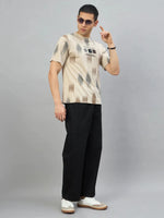 Man in streetwear—sunglasses, 98degreenorth Men’s Camel Abstract Ikat Print T-Shirt, black pants, and white sneakers.
