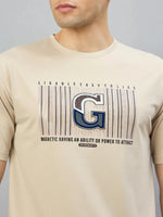 Man in 98degreenorth’s Men's Camel Graphic Oversized T-Shirt with a varsity G print.