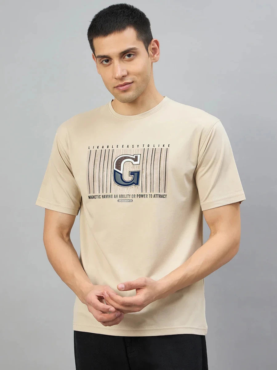 Man wearing 98degreenorth Men's Camel Graphic Oversized T-Shirt with Varsity G print, against a gray background.