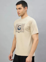 Man in a 98degreenorth Men's Camel Graphic Oversized T-Shirt with Varsity G print, against a plain gray background.