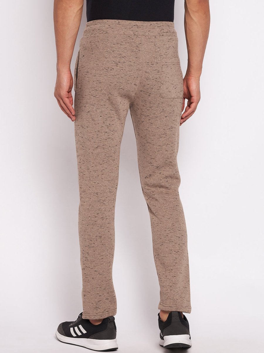 Model in 98degreenorth Men’s Camel Melange Fleece Trackpants and black sneakers, back view on white background.