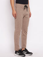 Model wears 98degreenorth Men’s Camel Melange Fleece Trackpants with a drawstring waist and black sneakers.