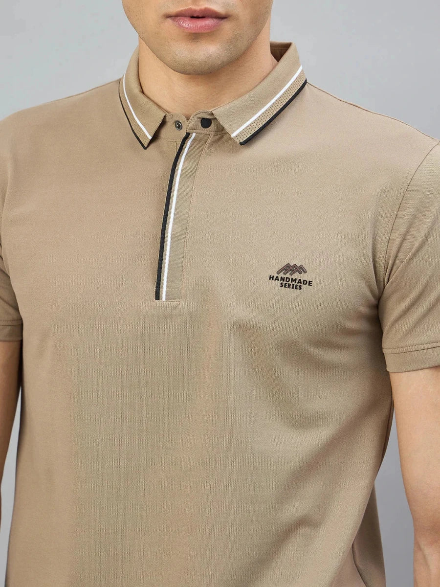 A man wears the 98degreenorth Men's Camel Polo—Handmade Series, with contrast tipping and chest logo.