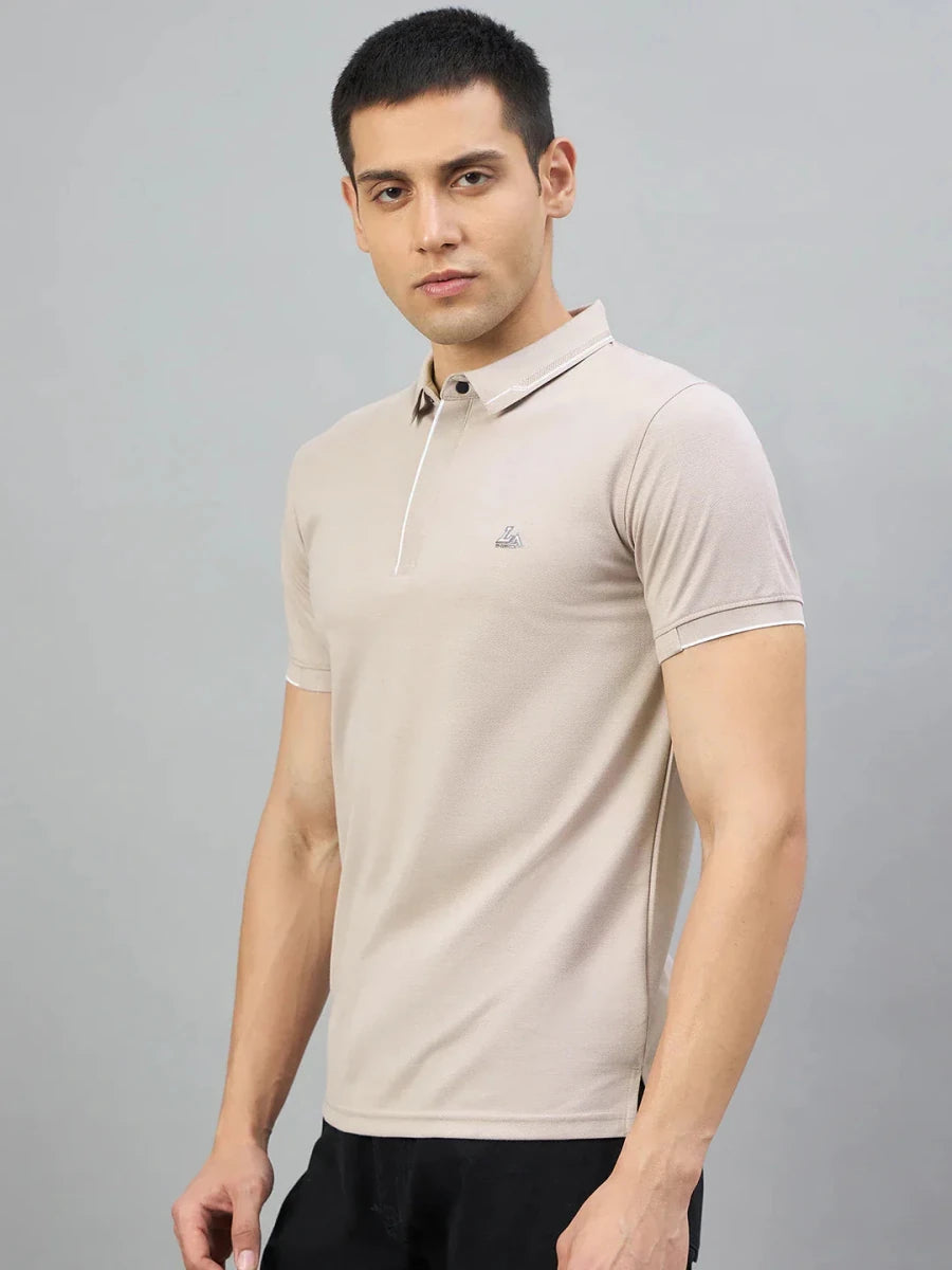 Man wearing a 98degreenorth Men's Camel Polo T-Shirt with White Tipping and LA Logo, against a grey background.