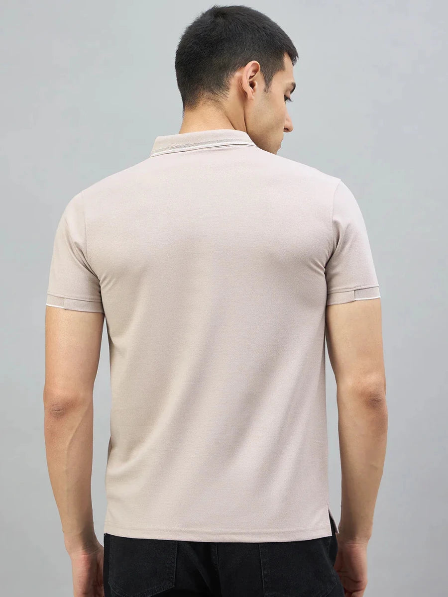 A man wears a 98degreenorth Men's Camel Polo T-Shirt with White Tipping, shown from the back on a gray background.