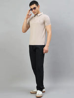 Man in 98degreenorth Men's Camel Polo T-Shirt with White Tipping stands against a plain gray background.