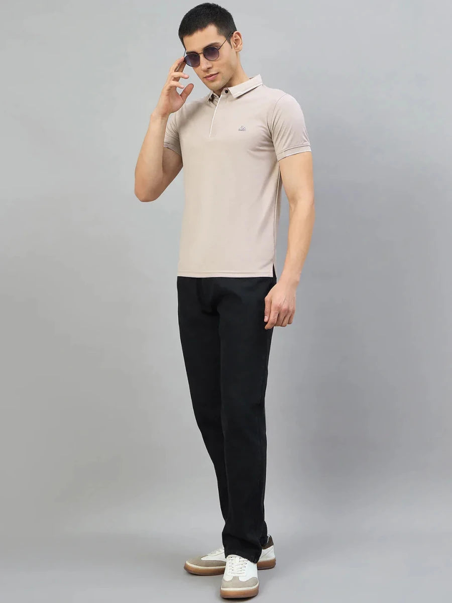 Man in 98degreenorth Men's Camel Polo T-Shirt with White Tipping stands against a plain gray background.