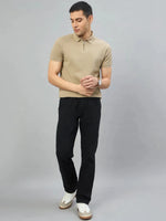 Man in a 98degreenorth Men's Camel Quarter Zip Polo T-Shirt, black pants, and white sneakers on a gray background.