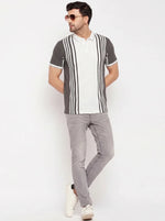 Man in 98degreenorth Charcoal Grey Vertical Striped Polo T-Shirt, gray jeans, and white sneakers on a white background.