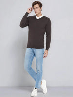 Man in a 98degreenorth Charcoal Merino Wool V-Neck Sweater, white shirt, blue jeans, and white sneakers.