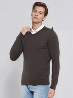 A man wears the 98degreenorth Men’s Charcoal Merino Wool V-Neck Sweater over a white shirt and jeans.