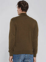 A man in a 98degreenorth Men’s Coffee Merino Wool Turtle Neck Sweater and blue jeans stands with his back to the camera.