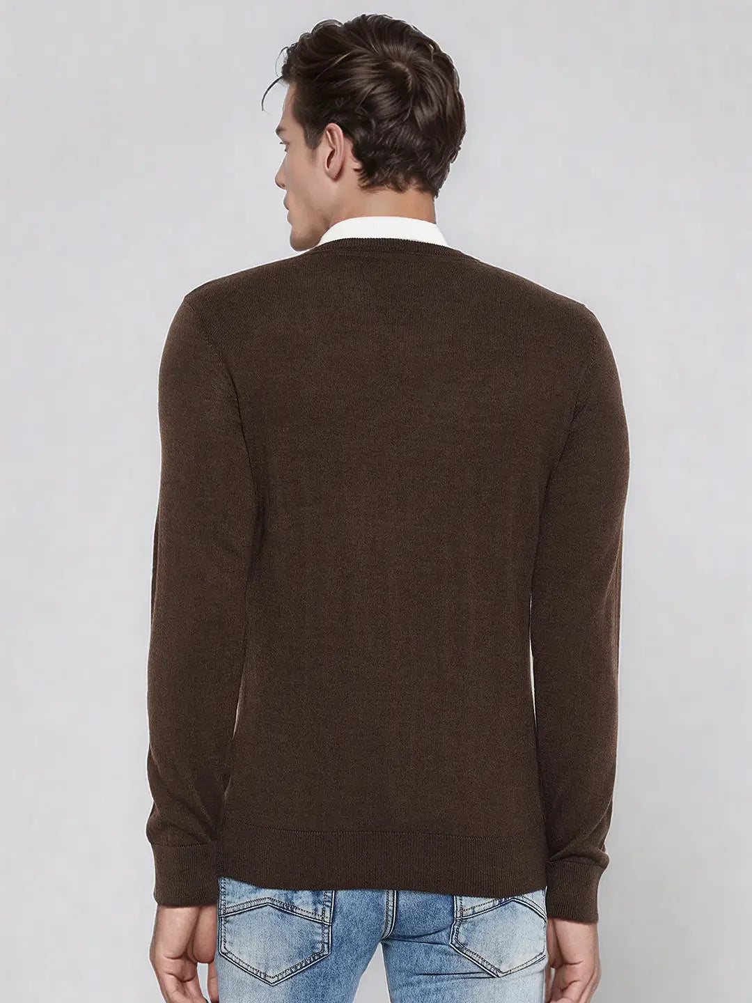 A man wears the 98degreenorth Men’s Coffee Merino Wool V-Neck Sweater, shown from the back on a light background.