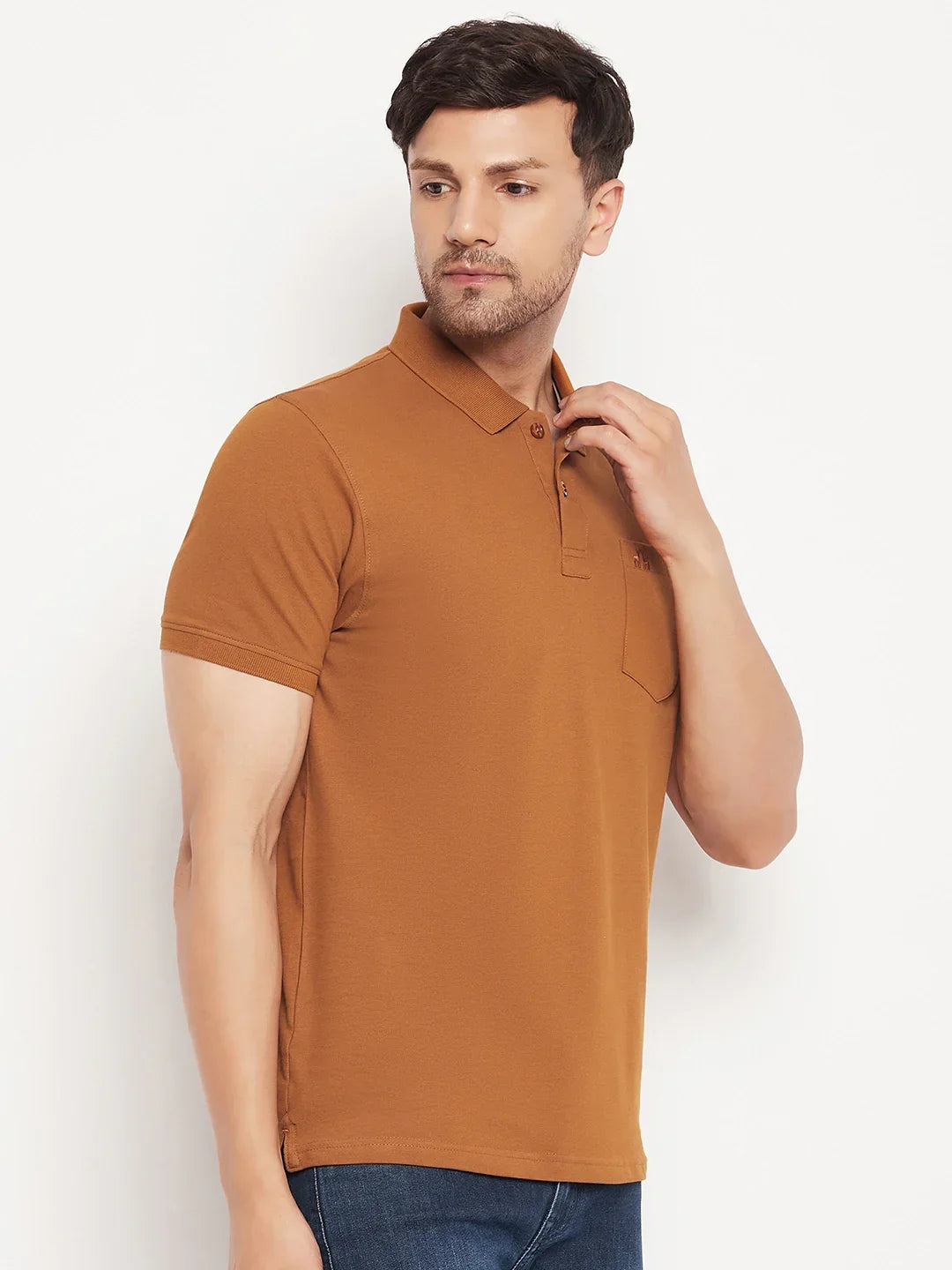 Man in 98degreenorth Men’s Copper Polo—Pure Cotton Pique with Chest Pocket—wears blue jeans, standing sideways.