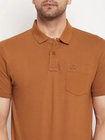 A man wears the 98degreenorth Men's Copper Polo T-Shirt in pure cotton pique with a chest pocket, shoulders to waist.