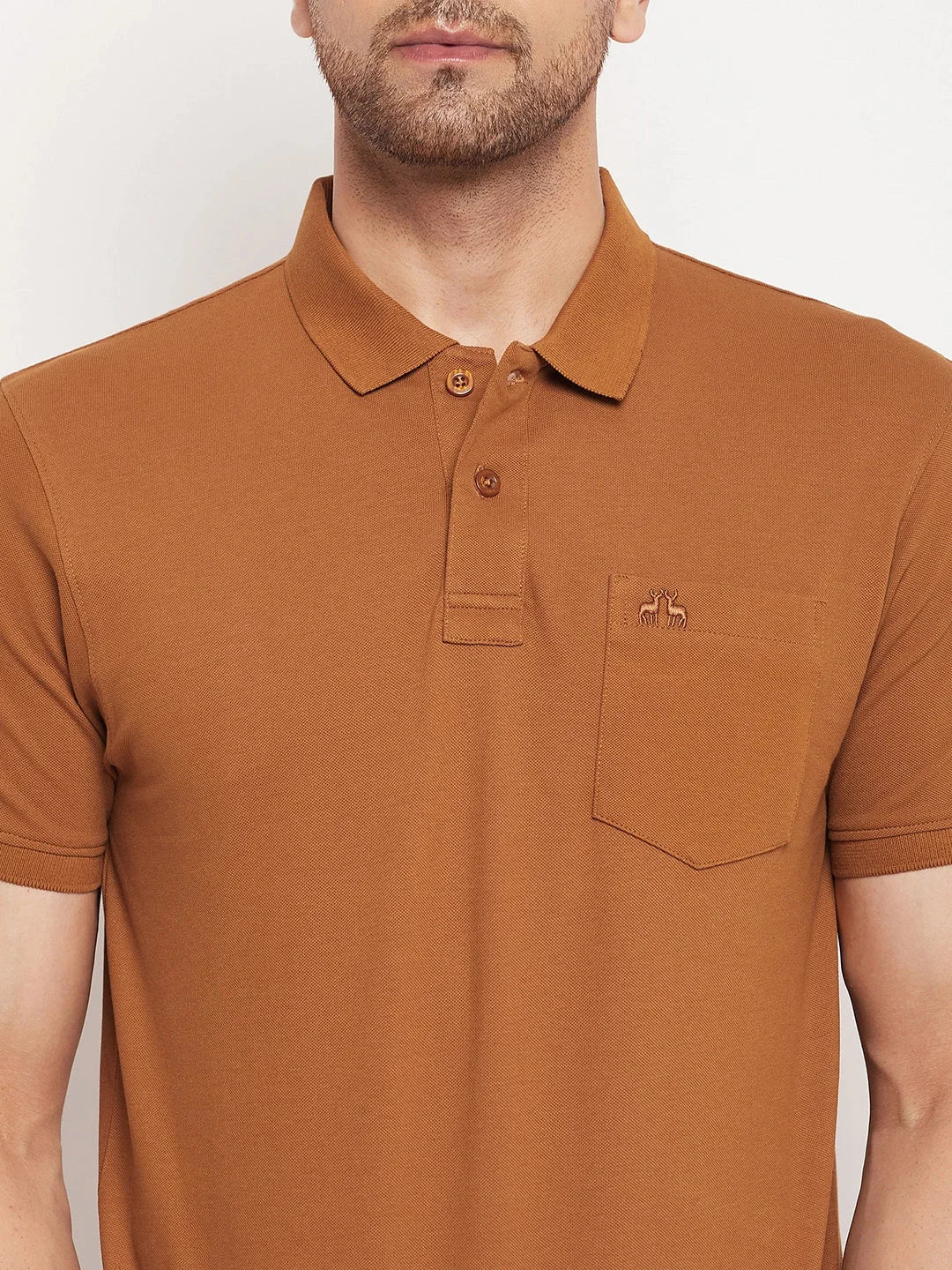 A man wears the 98degreenorth Men's Copper Polo T-Shirt in pure cotton pique with a chest pocket, shoulders to waist.
