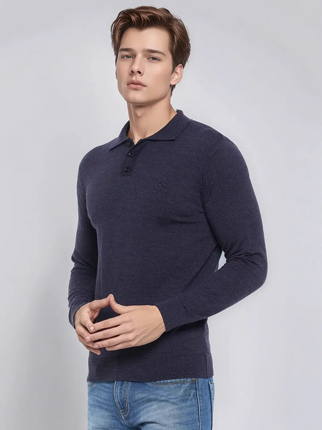 A man models the 98degreenorth Men’s Dark Denim Merino Wool Polo Neck Sweater against a plain light background.