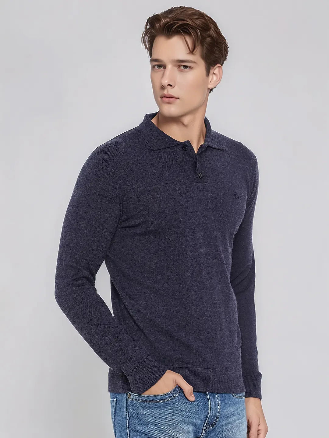 A man wears the 98degreenorth Men’s Dark Denim Merino Wool Polo Neck Sweater, a soft knit pullover for smart casuals.