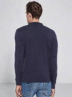 A man in blue jeans stands facing away, wearing a 98degreenorth dark denim merino wool polo neck sweater.