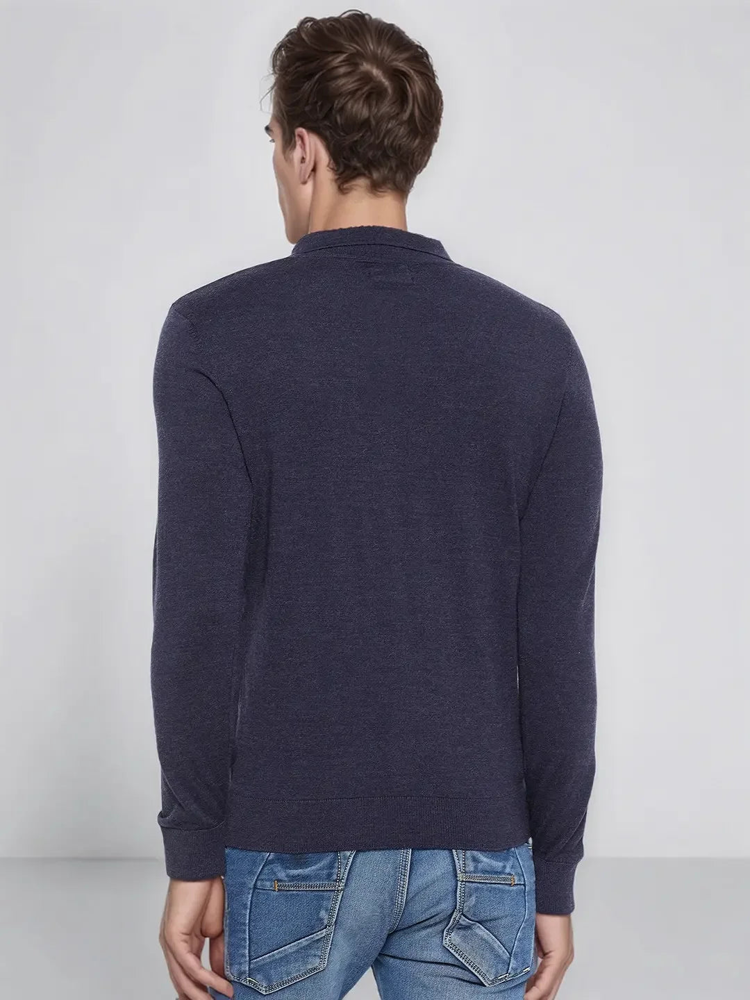 A man in blue jeans stands facing away, wearing a 98degreenorth dark denim merino wool polo neck sweater.