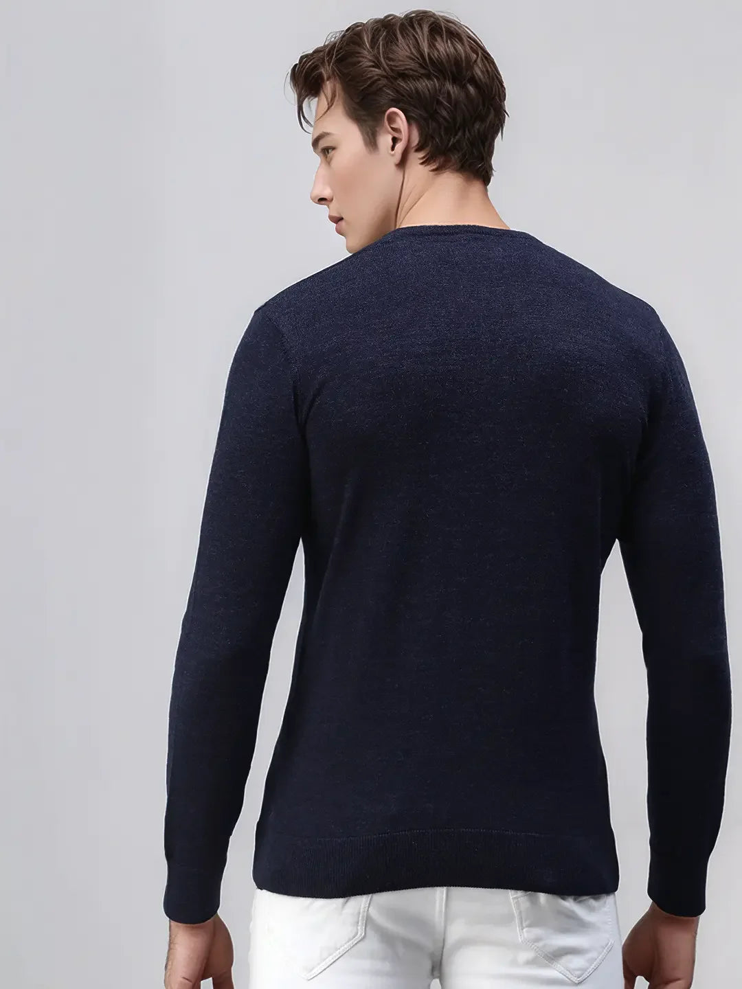 Man in 98degreenorth Dark Denim Merino Wool Sweater, luxury winter knit pullover, facing away, wearing white pants.