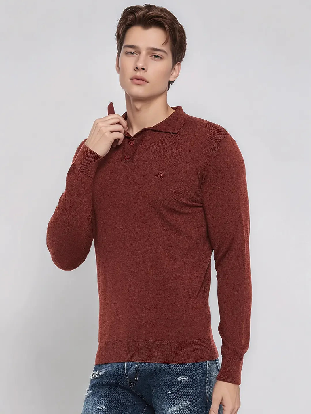 Young man in 98degreenorth’s dark maroon Merino wool polo neck sweater stands against a plain background.