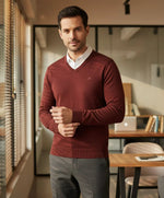 A man wears the 98degreenorth Men’s Dark Maroon Merino Wool V-Neck Sweater—perfect winter office wear.