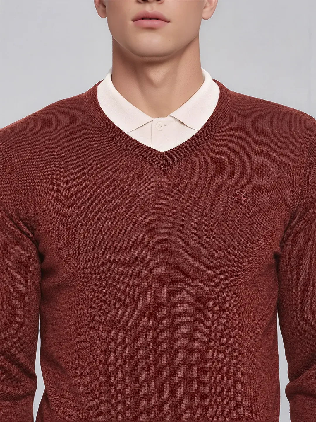 A man in a white shirt wears the 98degreenorth Men’s Dark Maroon Merino Wool V-Neck Sweater, perfect for winter meetings.