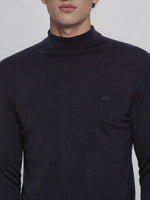 A man wears 98degreenorth’s dark navy merino wool turtleneck sweater—fine gauge knit, modern fit, subtle logo.