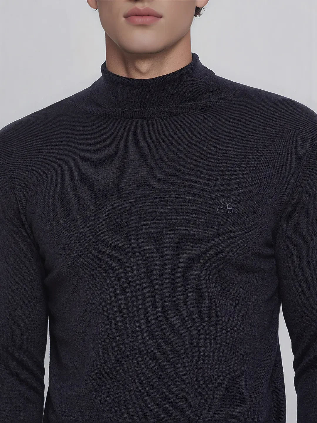 A man wears 98degreenorth’s dark navy merino wool turtleneck sweater—fine gauge knit, modern fit, subtle logo.
