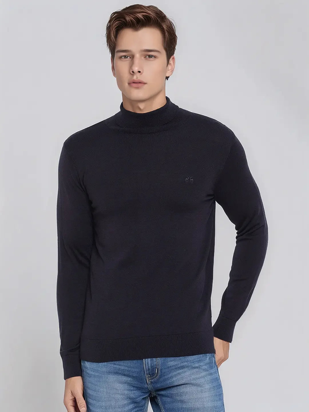 A man wears the 98degreenorth Dark Navy Merino Wool Turtle Neck Sweater against a plain light gray background.
