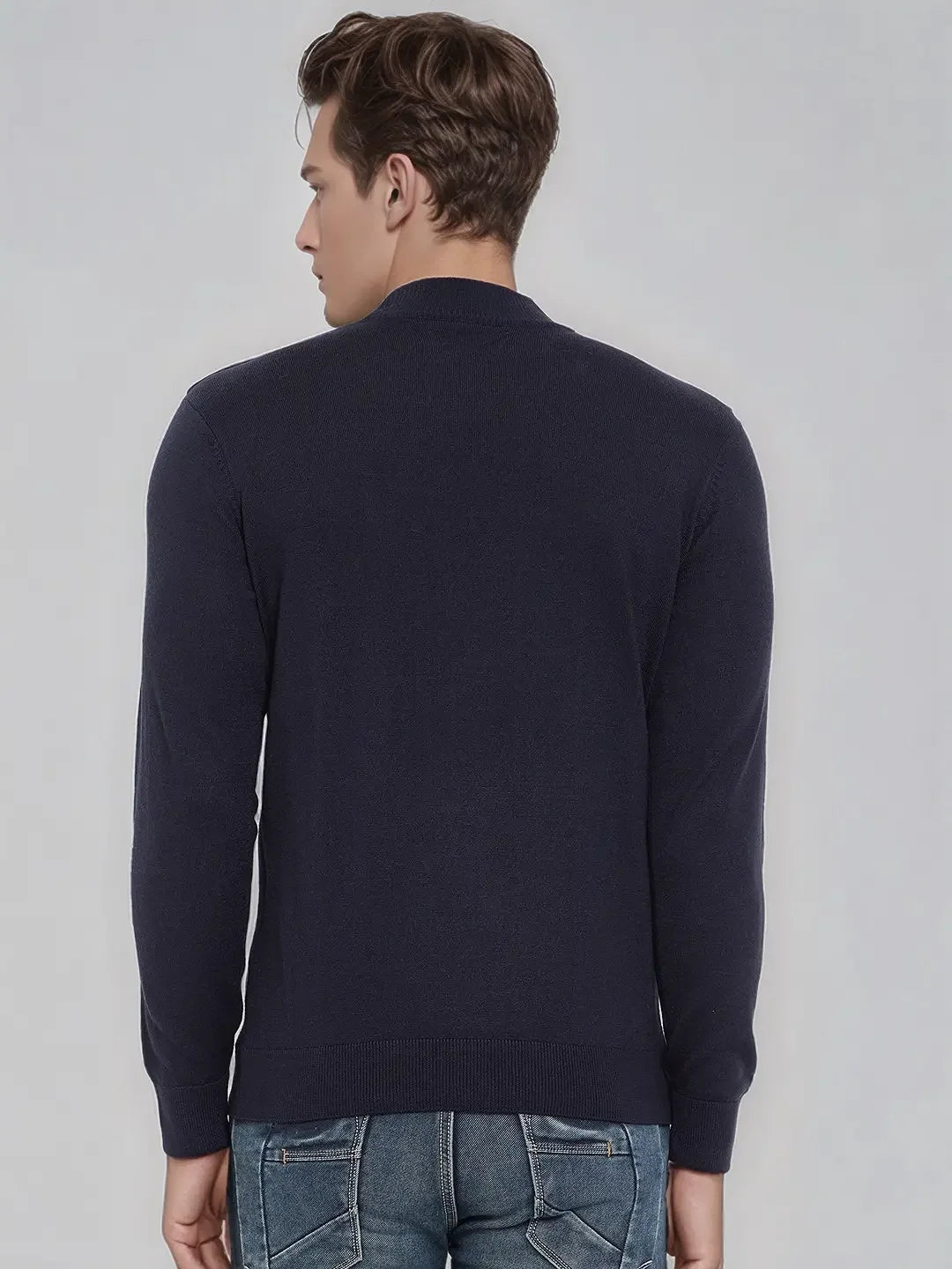 Man with short brown hair in a 98degreenorth Men’s Dark Navy Merino Wool Turtle Neck Sweater and blue jeans, back to camera.